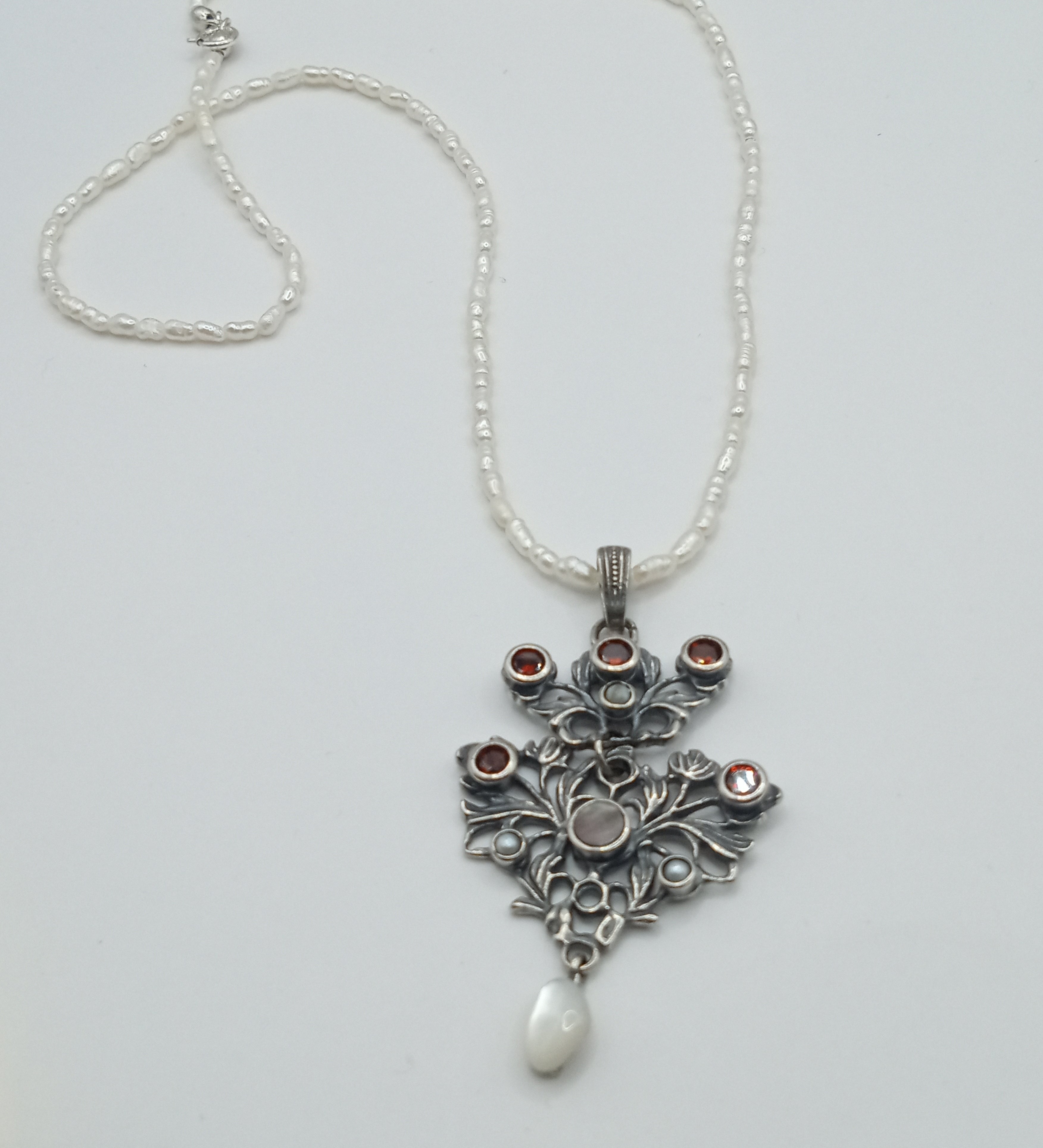 Austro-Hungarian style, adorned with mother-of-pearl natural pearl and garnet pendant