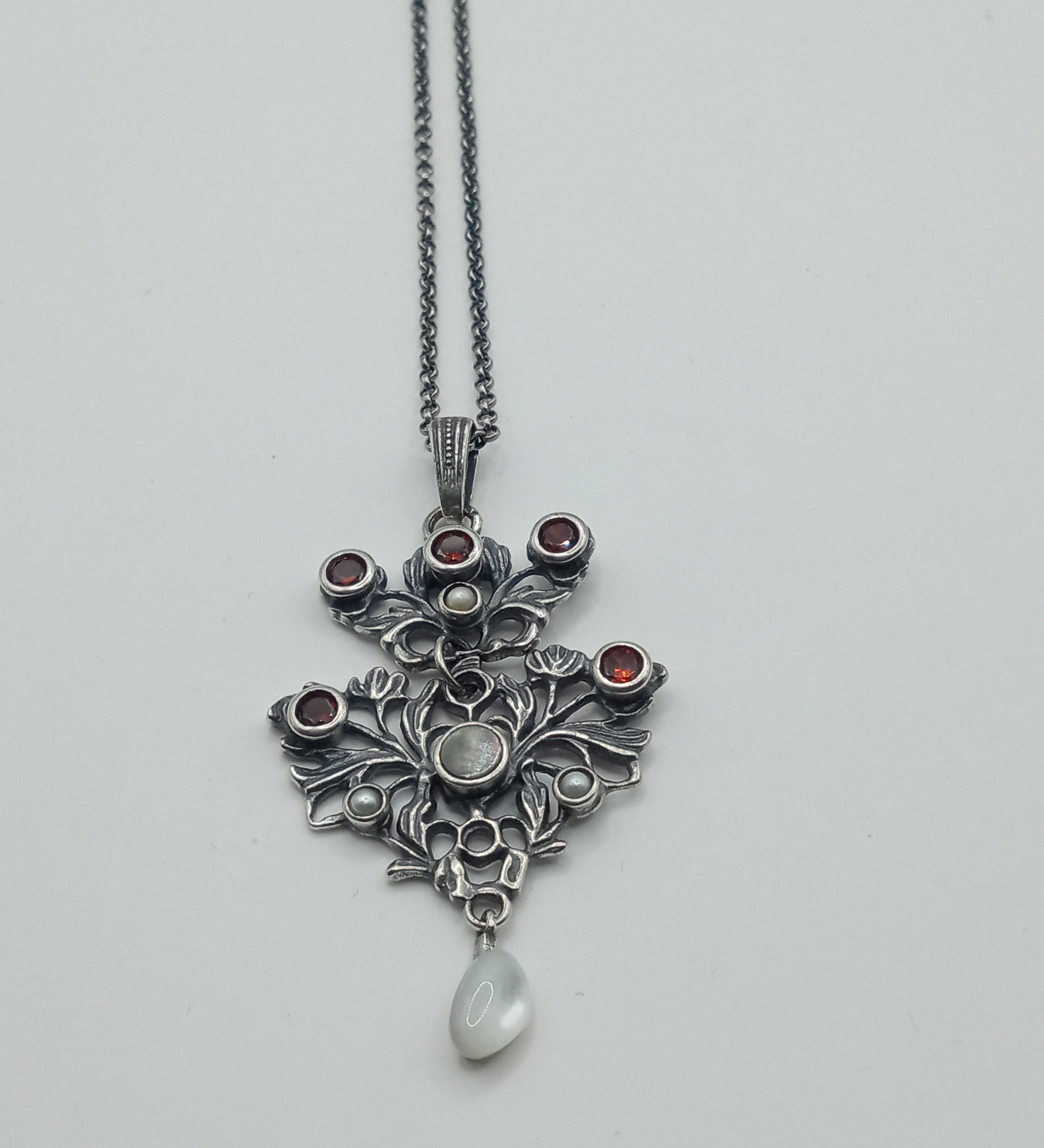 Austro-Hungarian style, adorned with mother-of-pearl natural pearl and garnet pendant